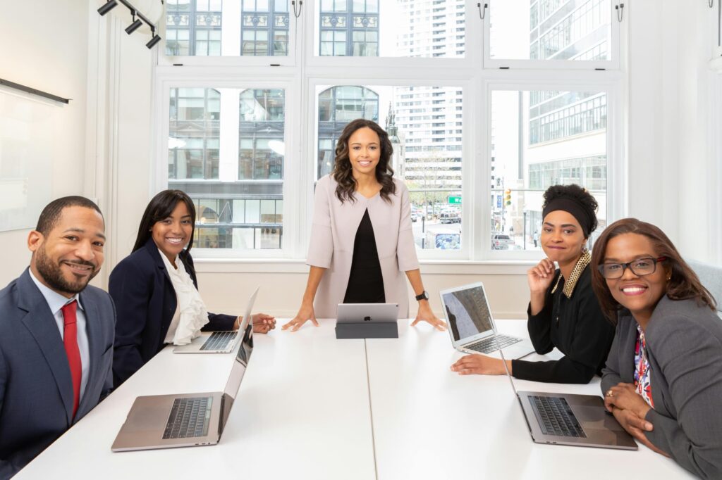 Three women sitting at a table with laptops.